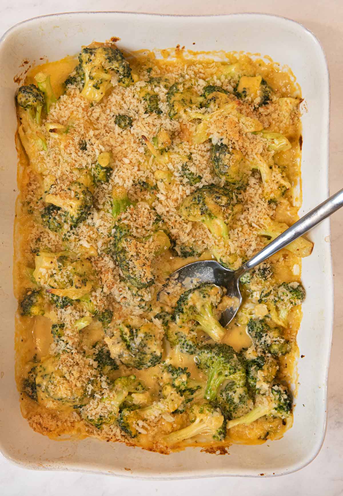 Cheesy Garlic Casserole in baking dish with spoon