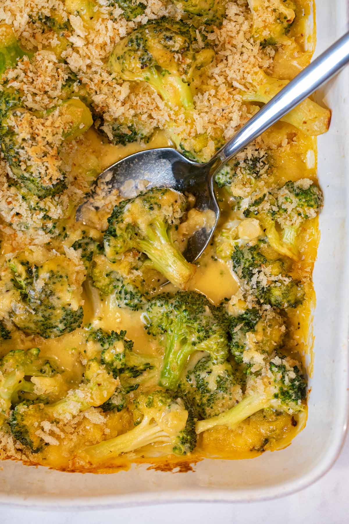 Cheesy Garlic Casserole in baking dish with spoon