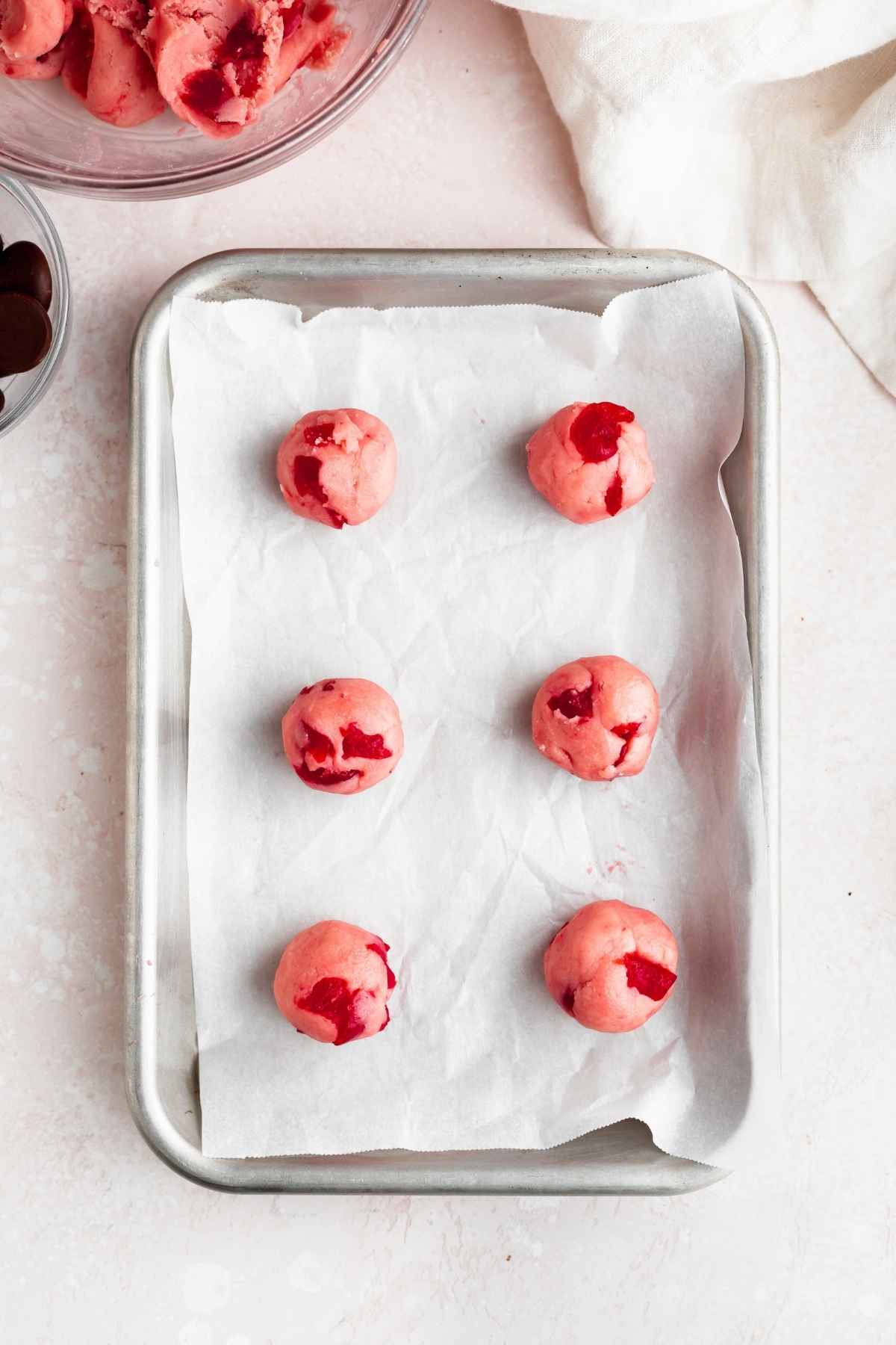 Cherry Kiss Cookies dough balls on baking sheet with parchment