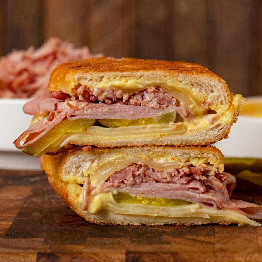 Cuban Sandwich halves stacked on cutting board