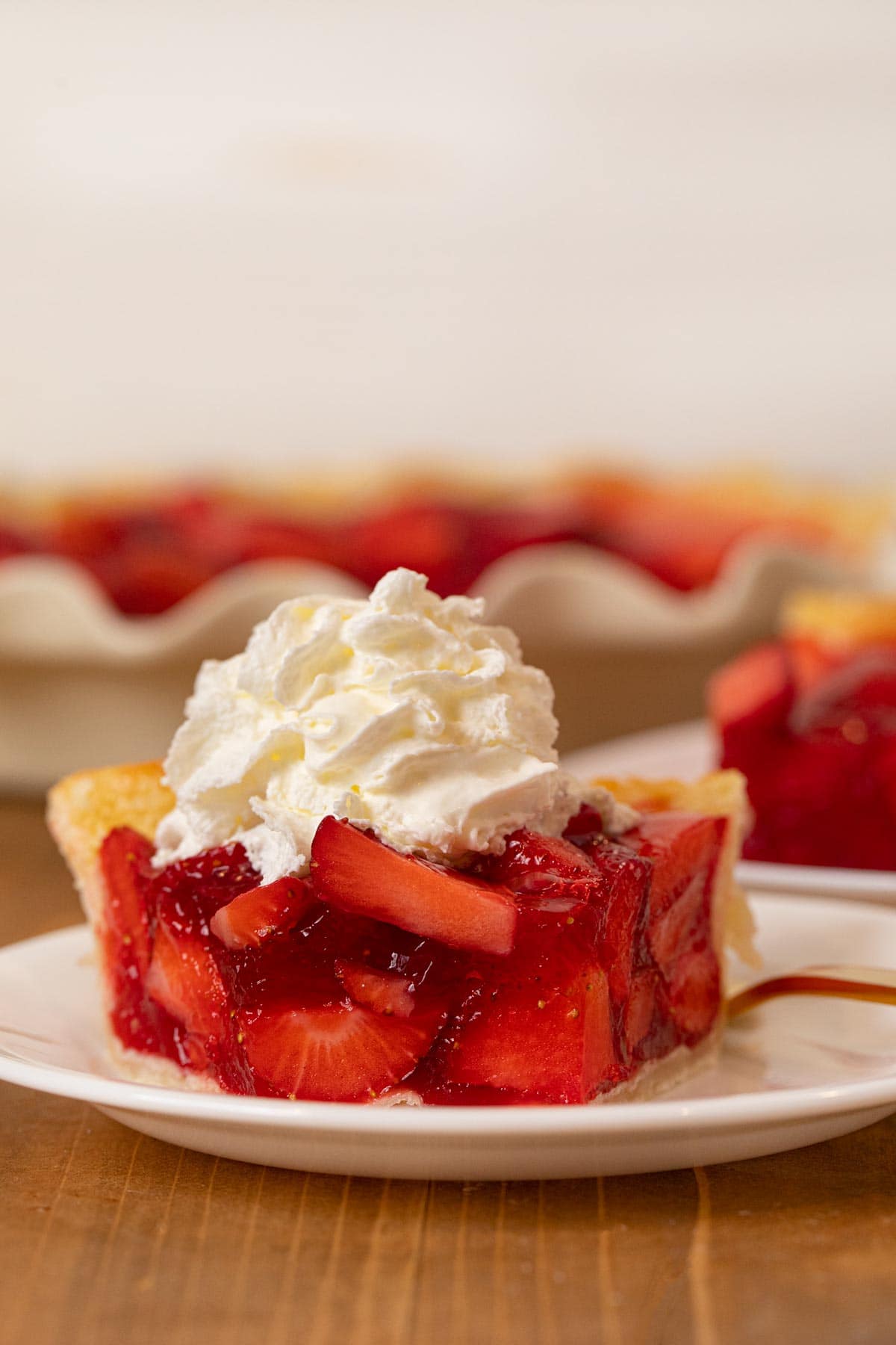 Fresh Strawberry Pie slice on plate with whipped cream