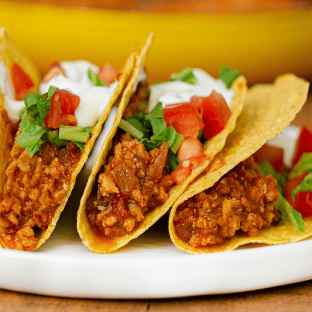 3 assembled tacos on a white plate