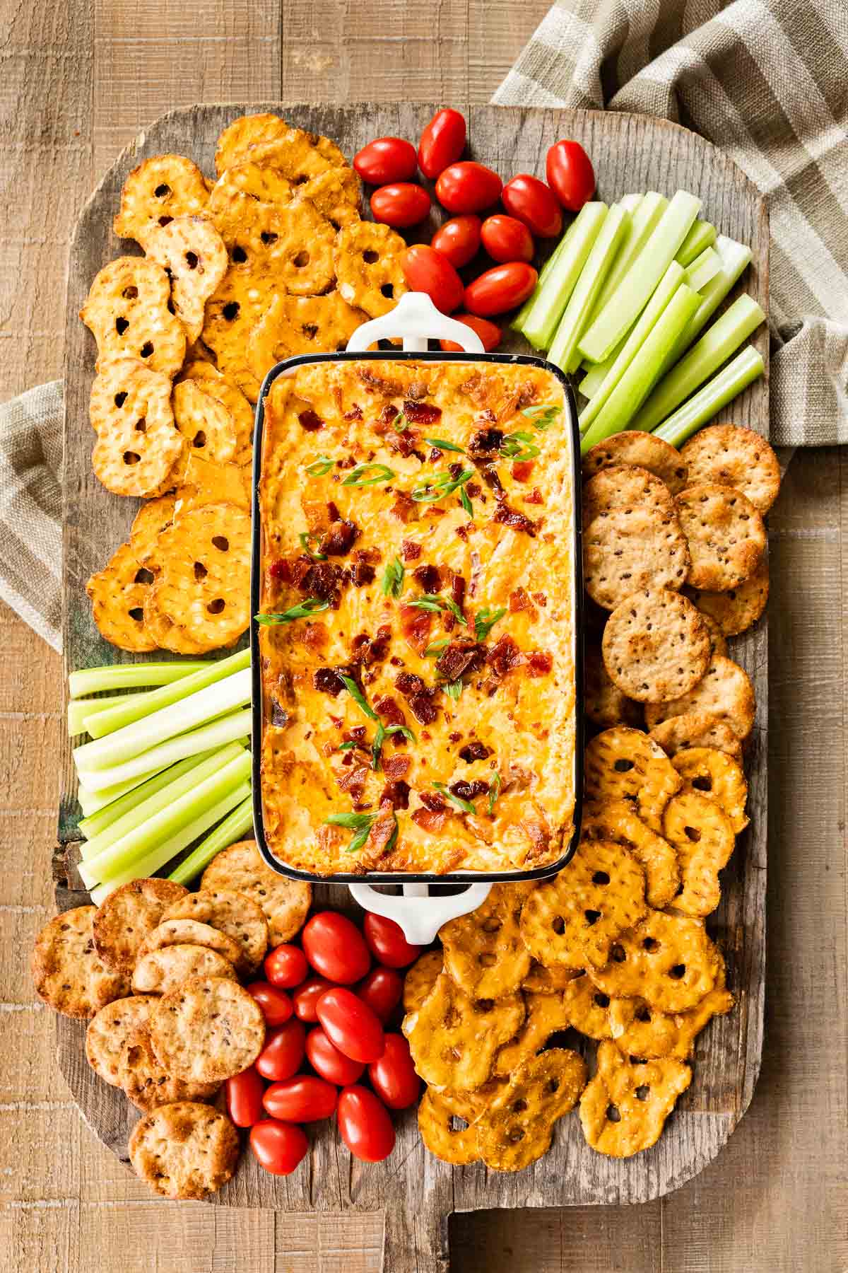 Hot Bacon Cheese Dip in baking dish with crackers and veggies