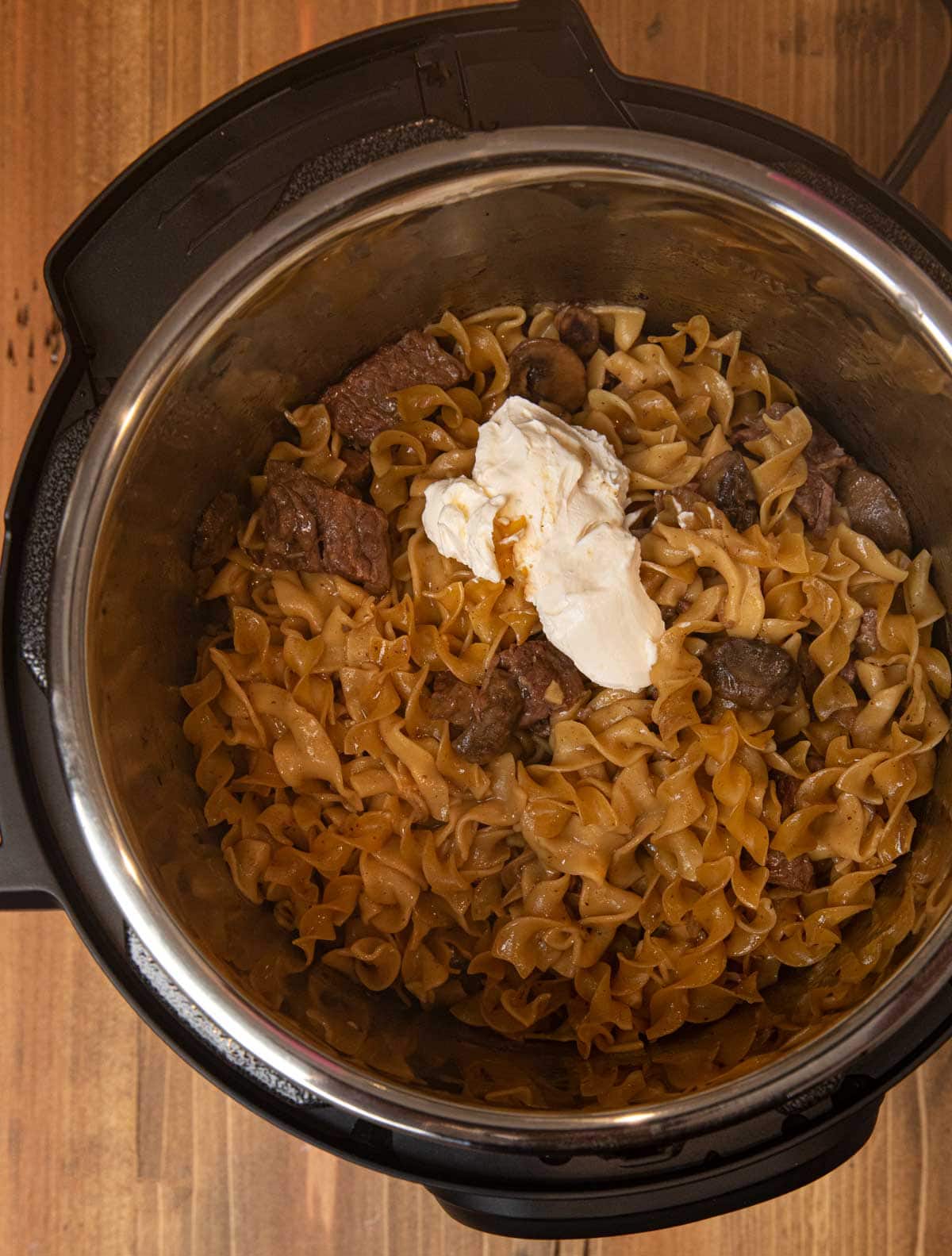 Instant Pot Beef Stroganoff and sour cream in pressure cooker