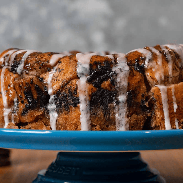 bread with glaze drizzled over the top on a teal serving platter