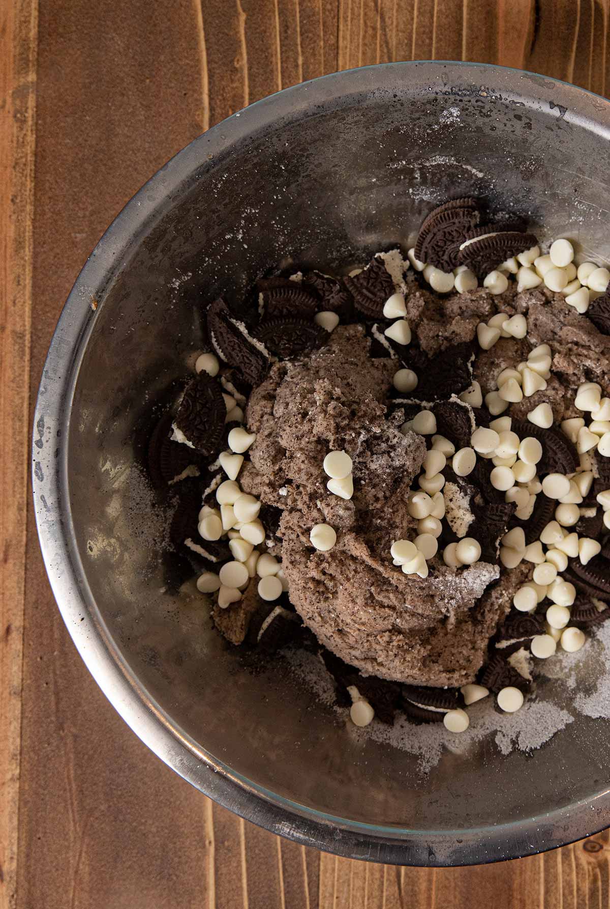 Oreo Scones dough in mixing bowl with oreo chunks and white chocolate chips