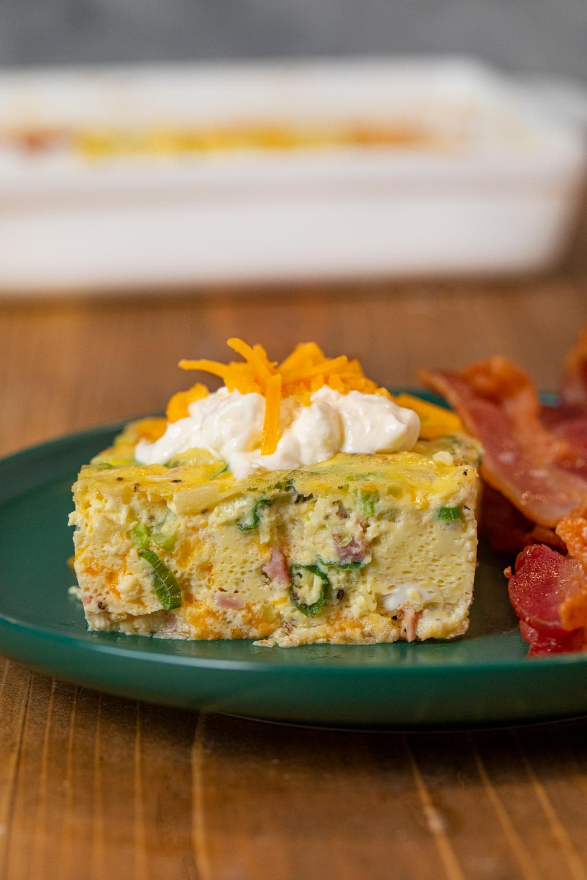 serving of Oven-Baked Omelette on plate with sour cream and bacon