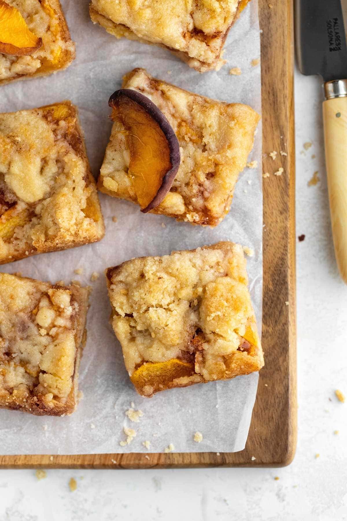 Peach Crumb Bars cut on parchment paper