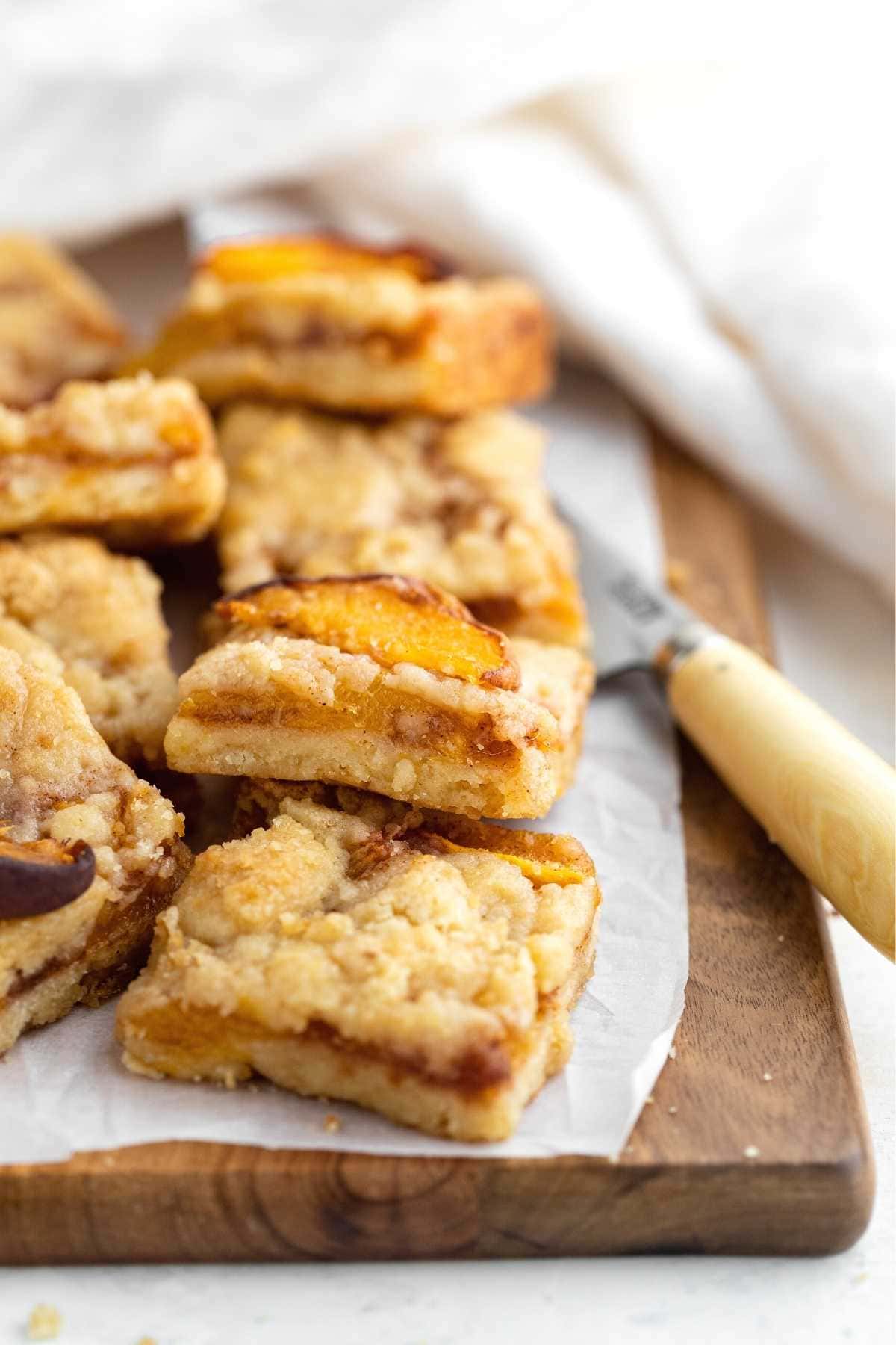 Peach Crumb Bars cut on parchment paper