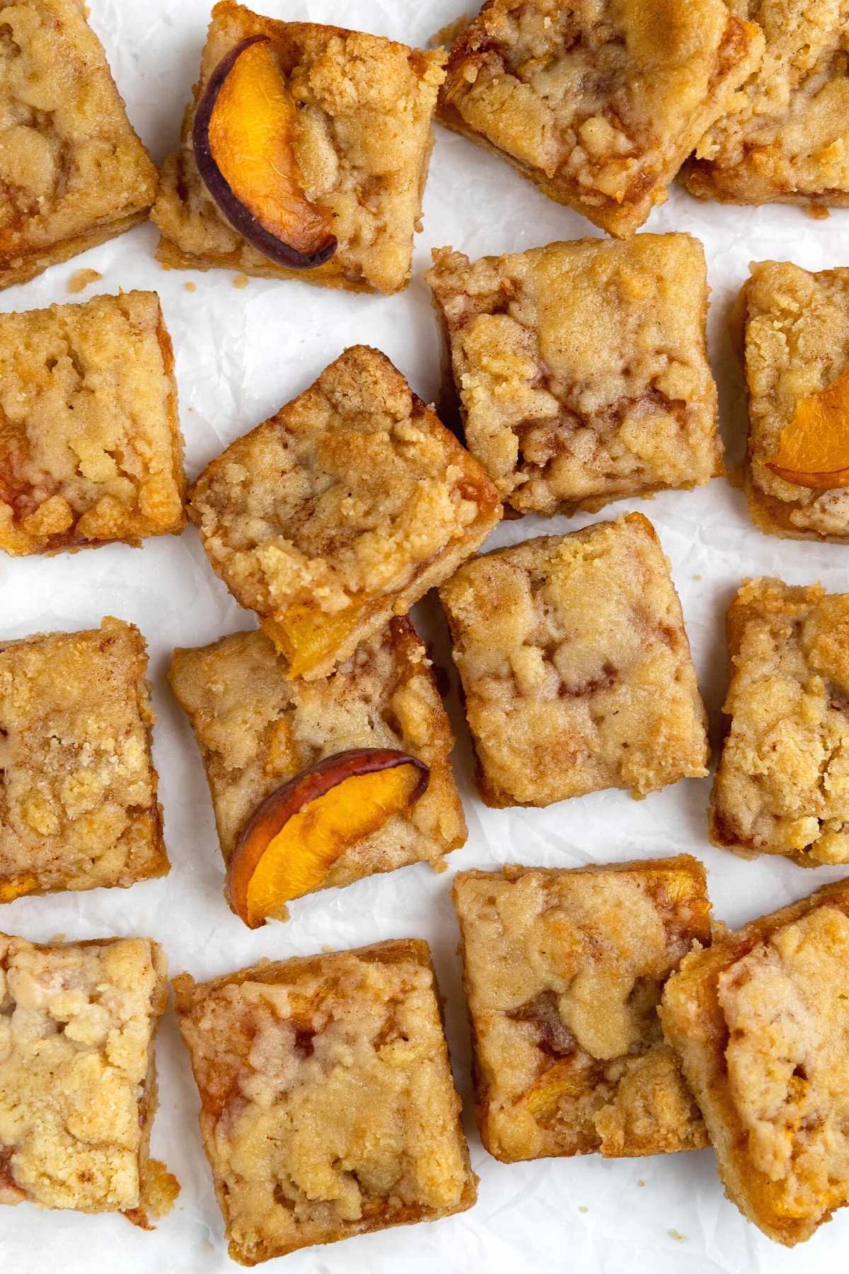 Peach Crumb Bars cut on parchment paper