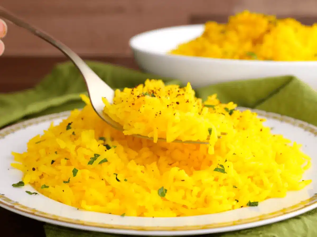 taking forkful of yellow rice