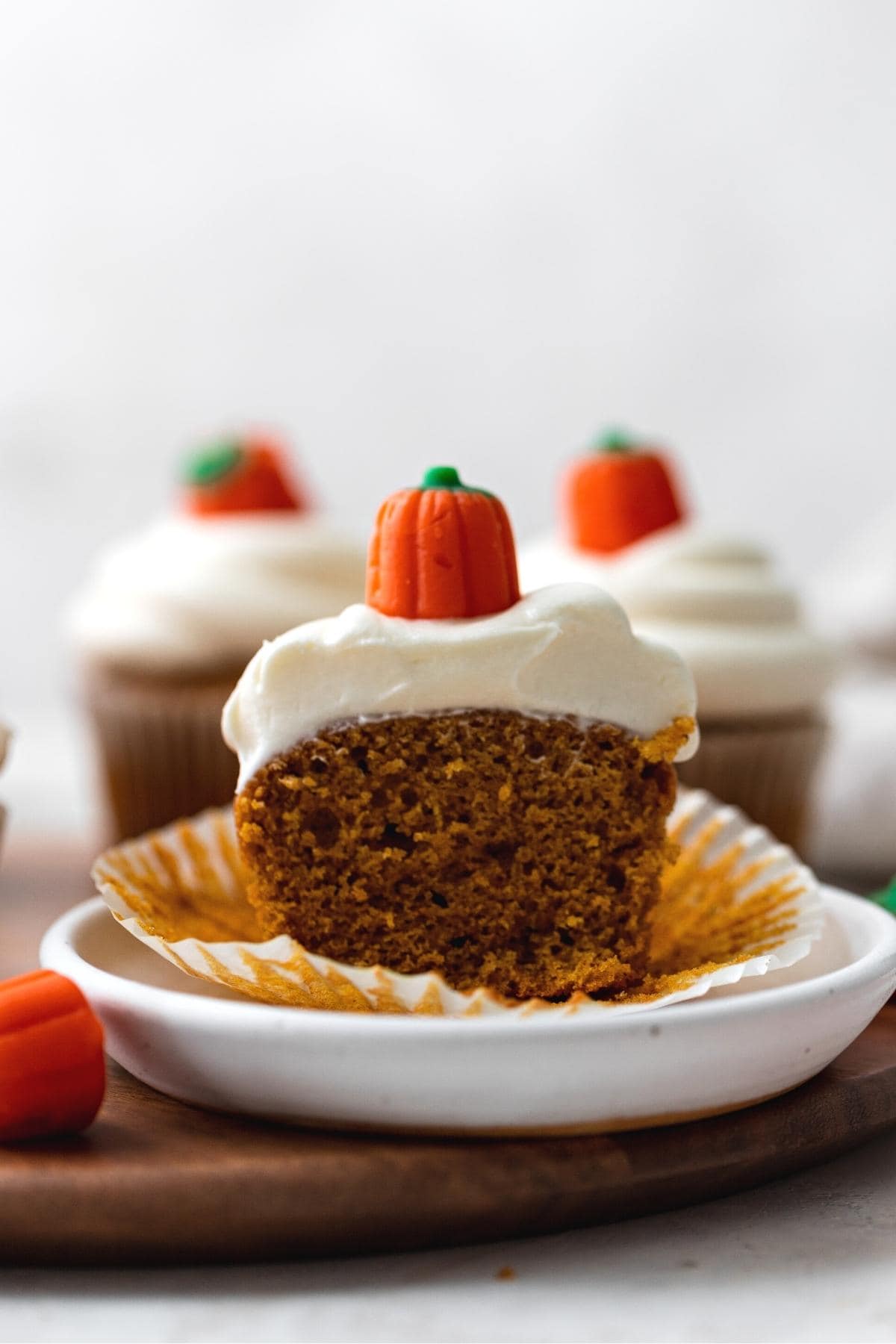 Pumpkin Cupcakes frosted with pumpkin candy on top, cut in half side view