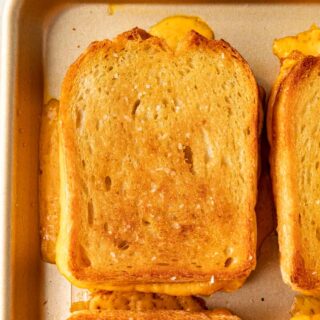 Sheet Pan Grilled Cheese Sandwiches are the easiest way to make ultimate cheesy, crispy cheese sandwiches for a crowd in less than 30 minutes! Sheet Pan Grilled Cheese baked on sheet pan close up on one sandwich