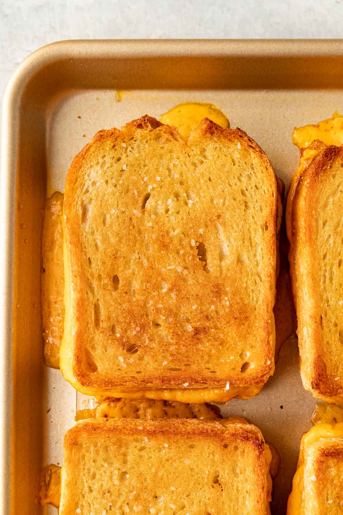 Sheet Pan Grilled Cheese baked on sheet pan close up on one sandwich