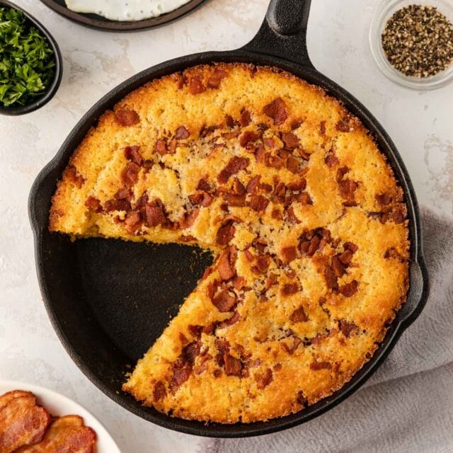 Skillet Bacon Cornbread in cooking pan with slice removed 1x1