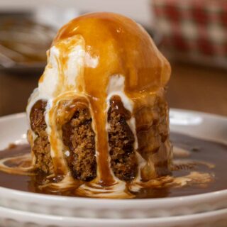 Sticky Toffee Pudding serving on plate with ice cream and sauce