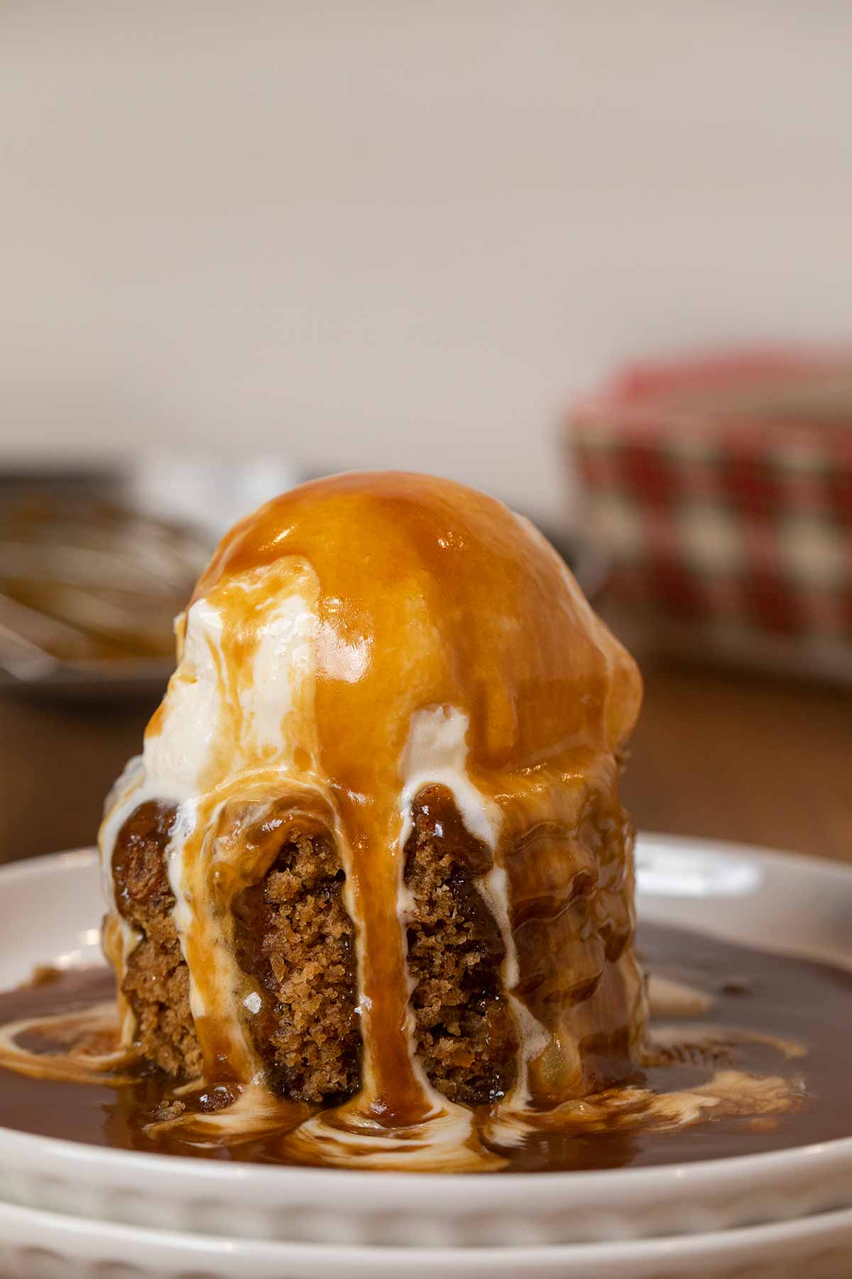 Sticky Toffee Pudding serving on plate with ice cream and sauce