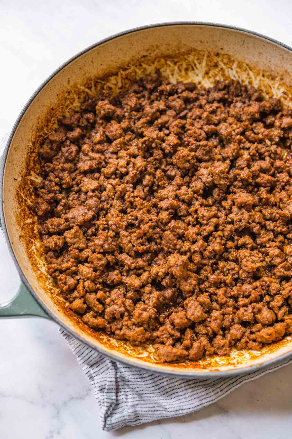 Seasoned ground beef in skillet for Taco Salad