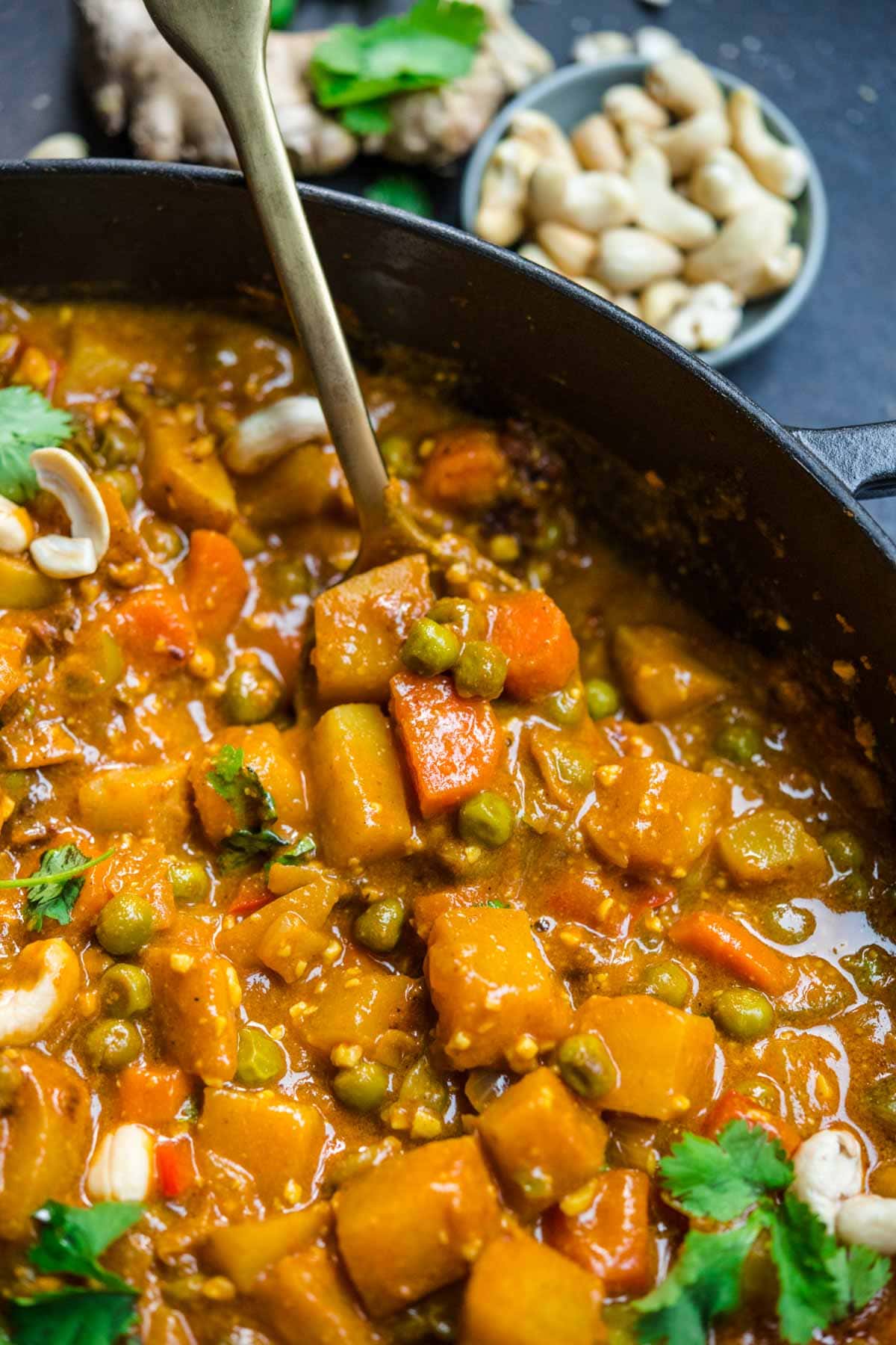 Vegetable Korma in serving bowl with cashews and cilantro garnish