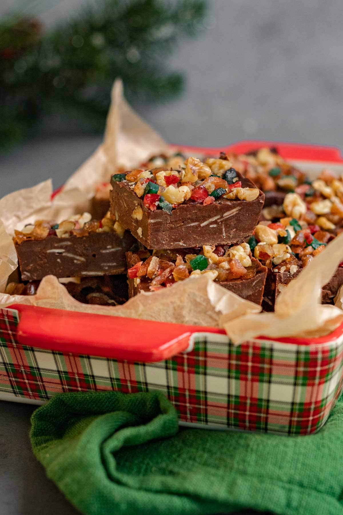 Christmas Fudge squares with nuts and candy on parchment in baking dish