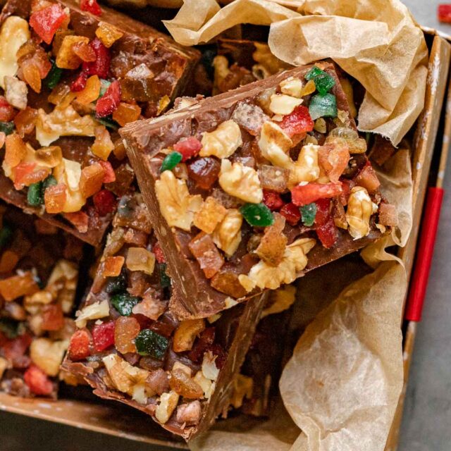 Fudge squares with nuts and candy on parchment in gift box
