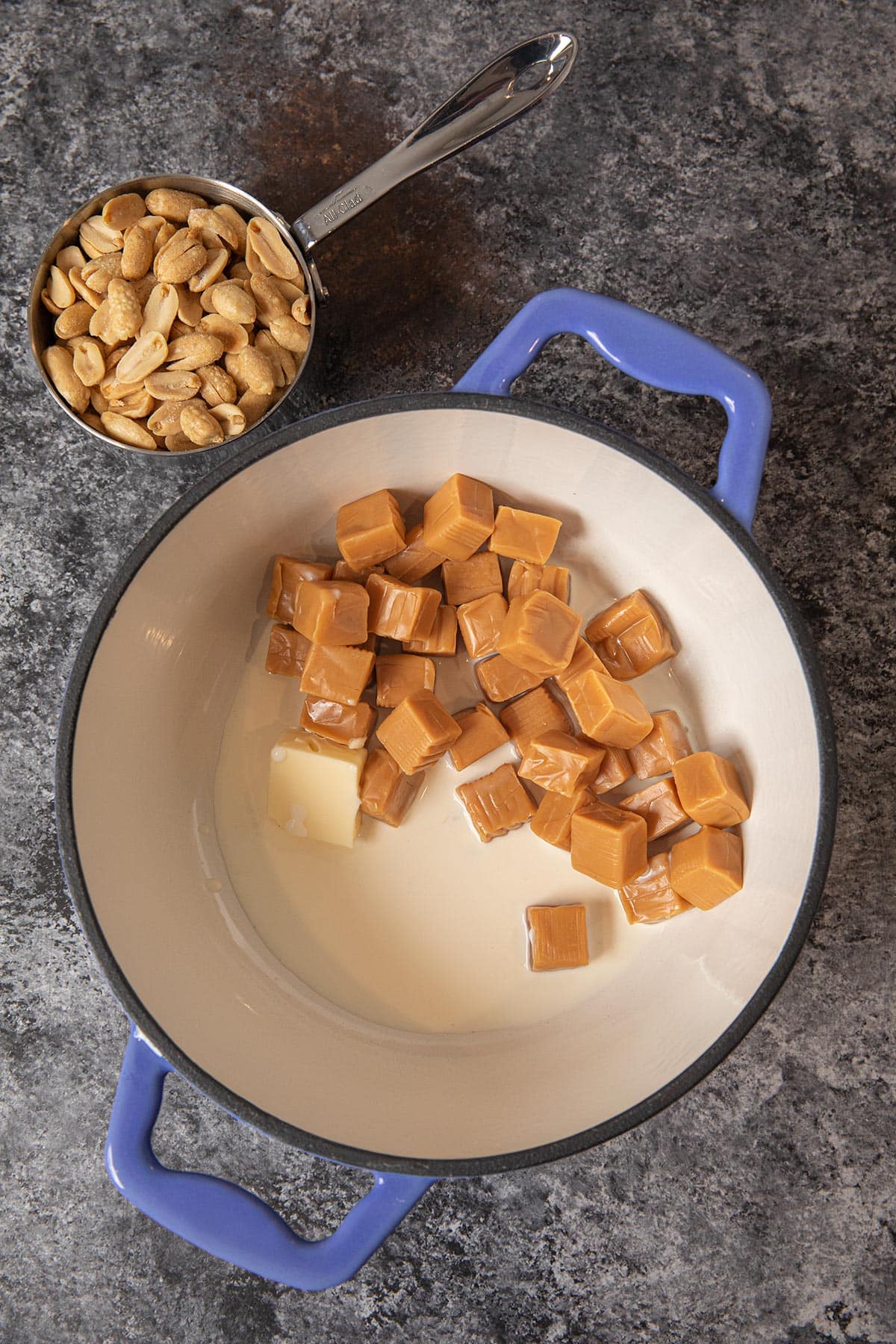 Caramel Peanut Clusters caramel in pot with peanuts in measuring cup