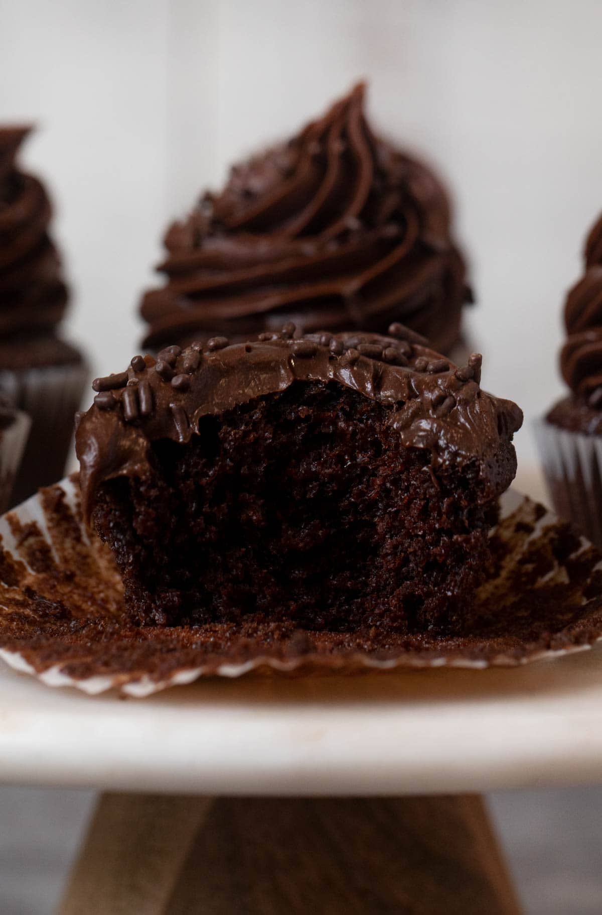 Chocolate Cupcake with Chocolate Frosting and chocolate sprinkles with bite removed