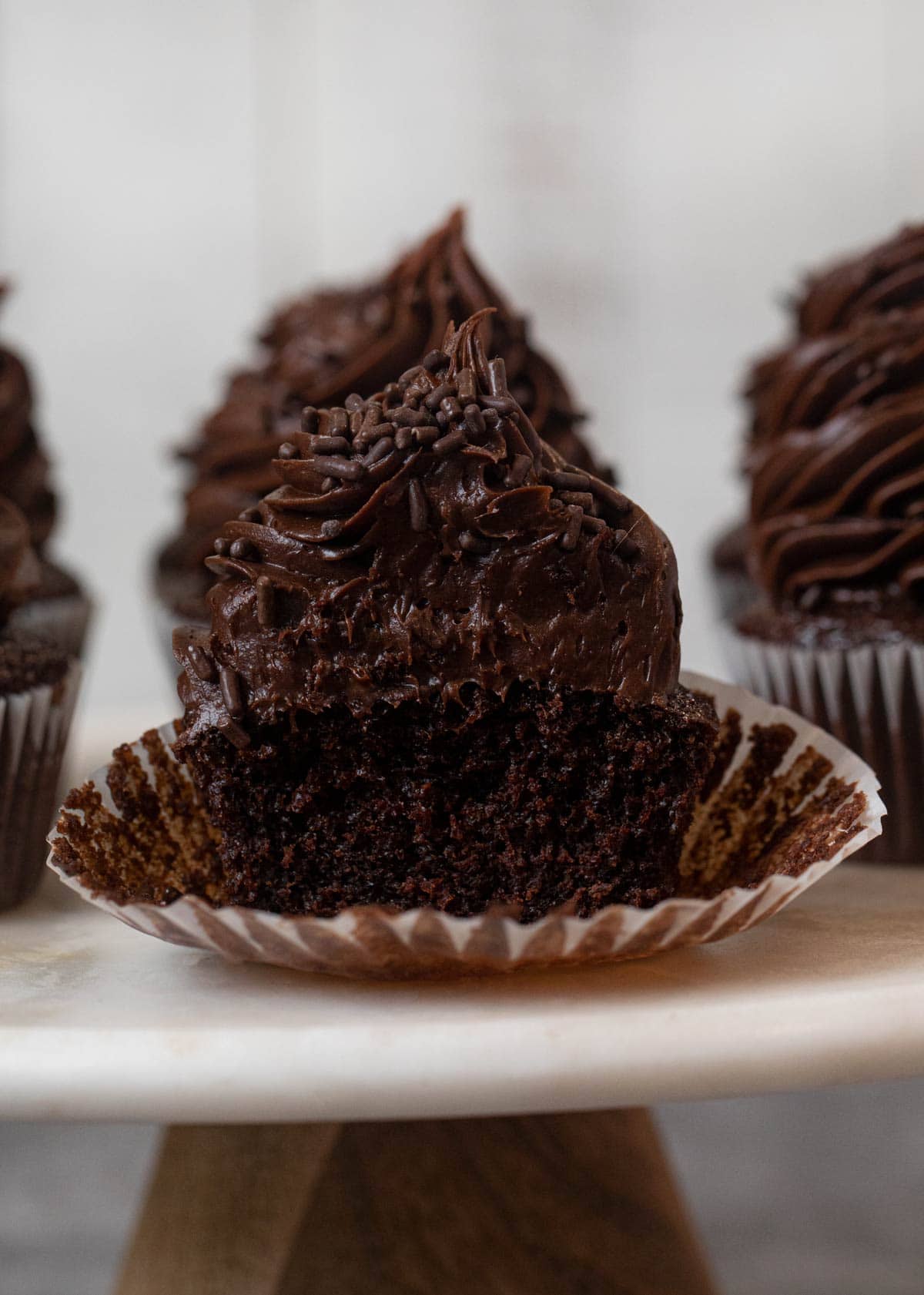 Chocolate Cupcake with Chocolate Frosting and chocolate sprinkles with bite removed