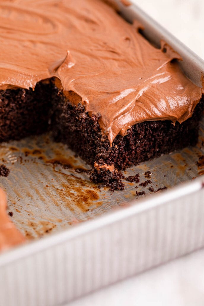 Chocolate Poke Cake Frosted in Baking Pan with slices removed