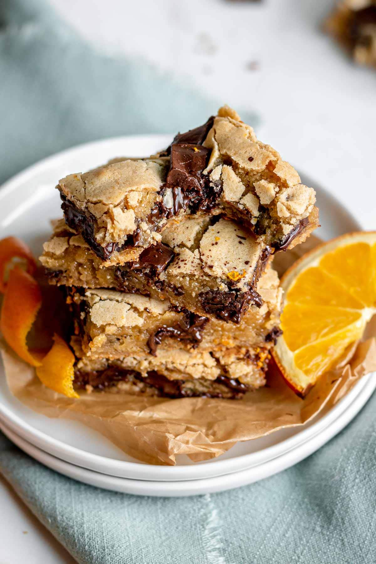 Dark Chocolate Orange Blondies stacked on serving plate showing interior