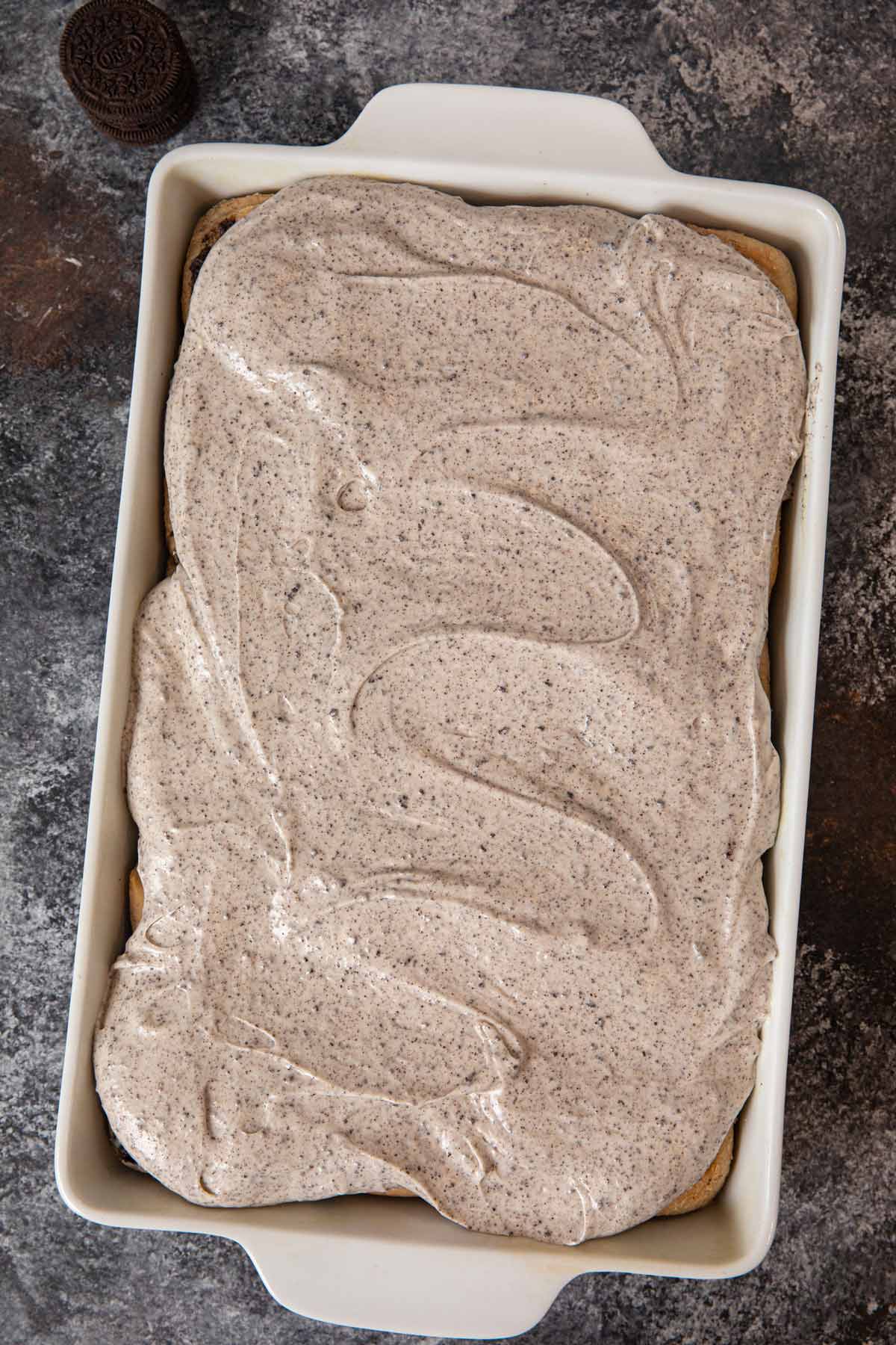 Oreo Cinnamon Rolls in baking dish with Oreo frosting