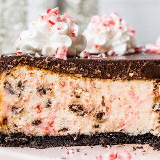 Peppermint Chocolate Cheesecake on cake plate with ganache topping, whipped cream and crushed candy canes on top 4x3