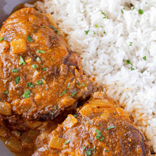 Chicken on a plate with rice on the side