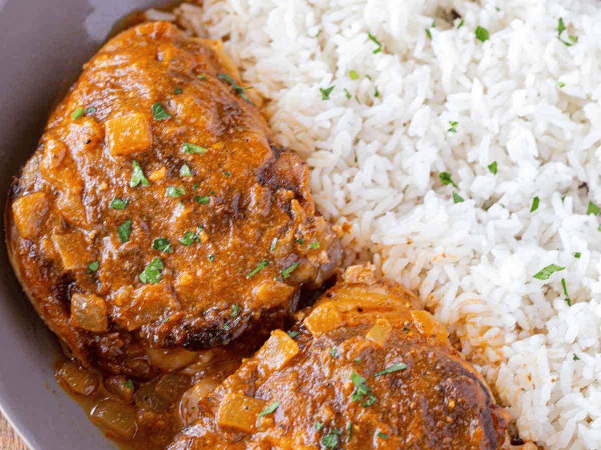 Chicken on a plate with rice on the side 