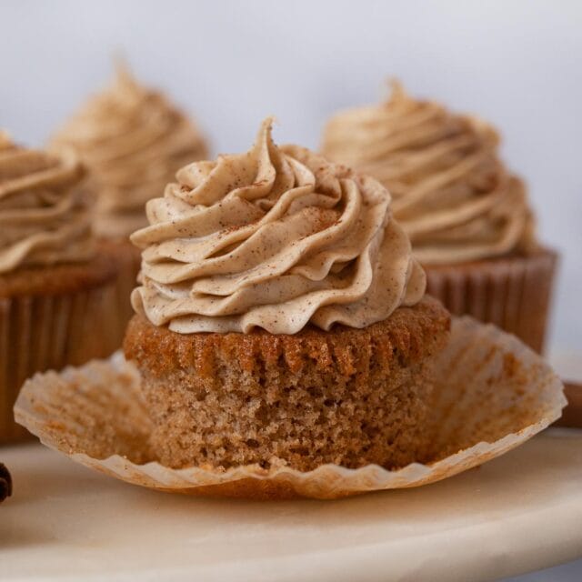 Snickerdoodle Cupcakes with liner removed on cake stand