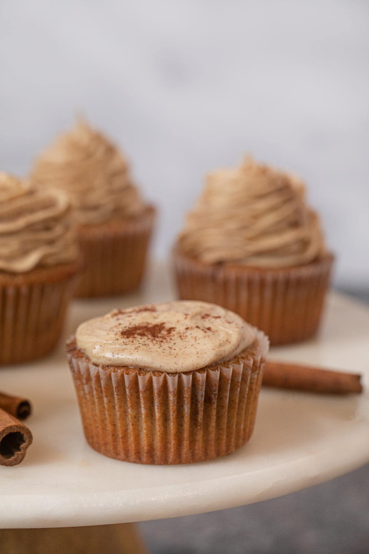 Snickerdoodle Cupcakes on cupcake stand topped with cinnamon