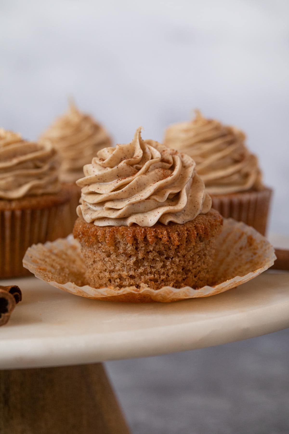 Snickerdoodle Cupcakes with liner removed on cake stand