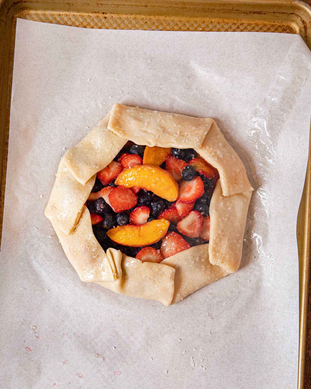 Unbaked fruit galette on parchment paper