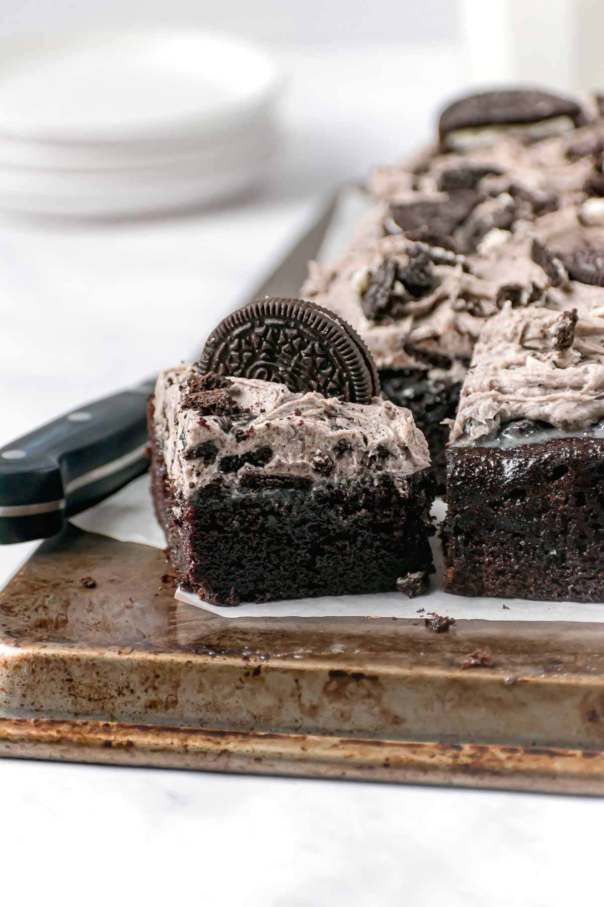 Oreo Poke Cake cut on serving board