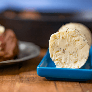 roll of creamy dairy spread on blue platter on table