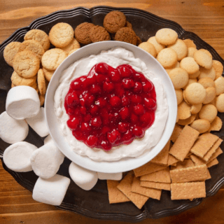 bowl of dip in the middle of a tray with assorted dippers
