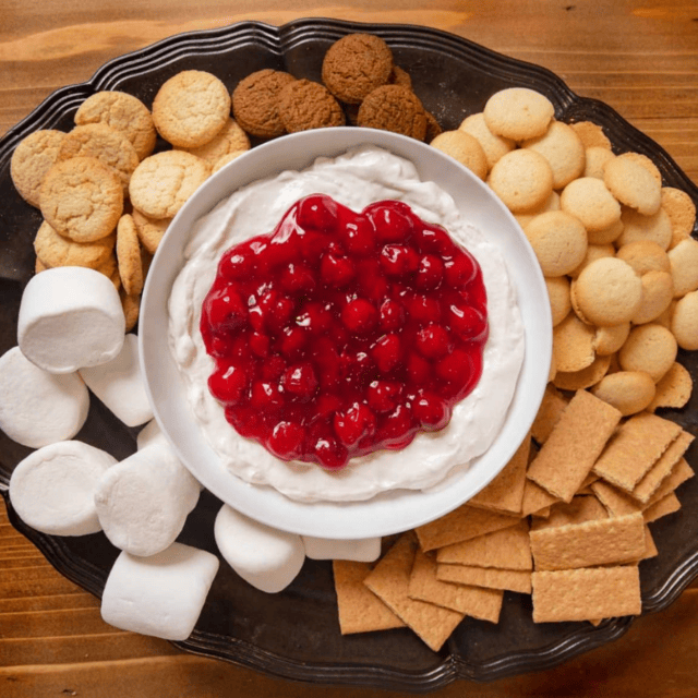 bowl of dip in the middle of a tray with assorted dippers