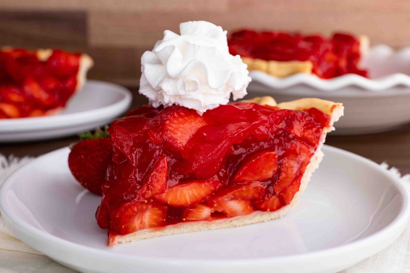 Fresh Strawberry Pie slice on plate with whipped cream