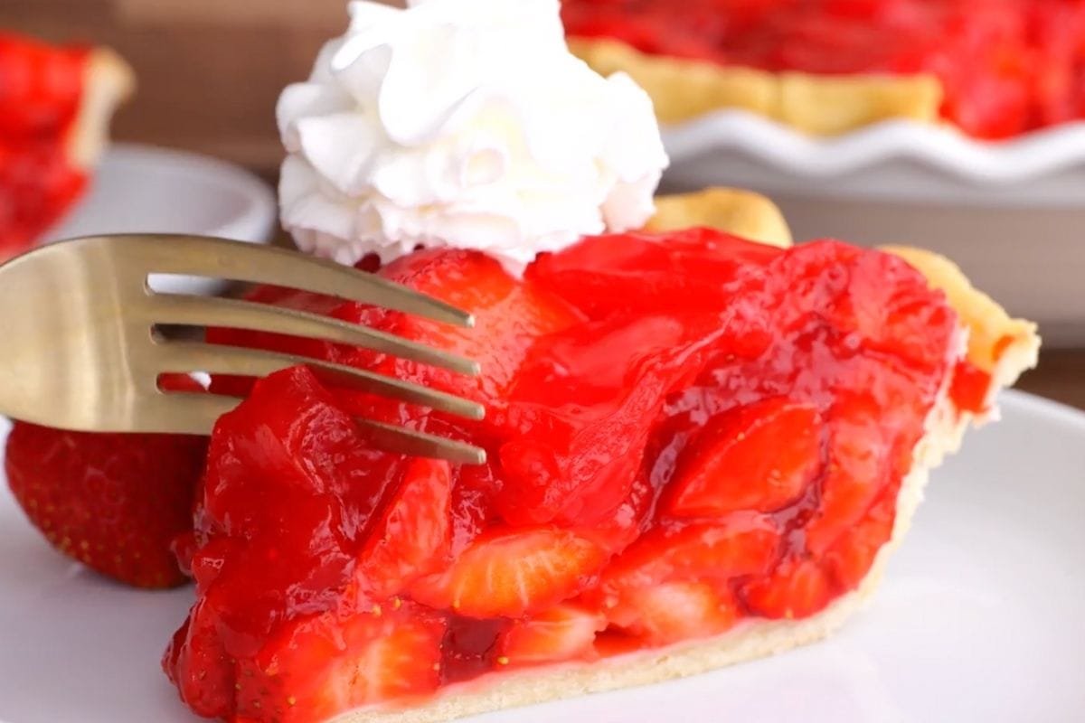 Fresh Strawberry Pie slice on plate with whipped cream and fork