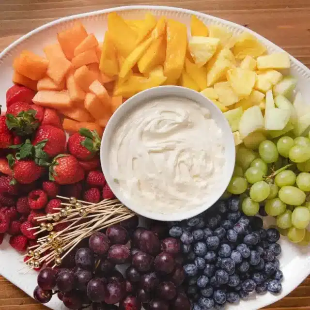 platter of dip in the center with colorful fruit surrounding it