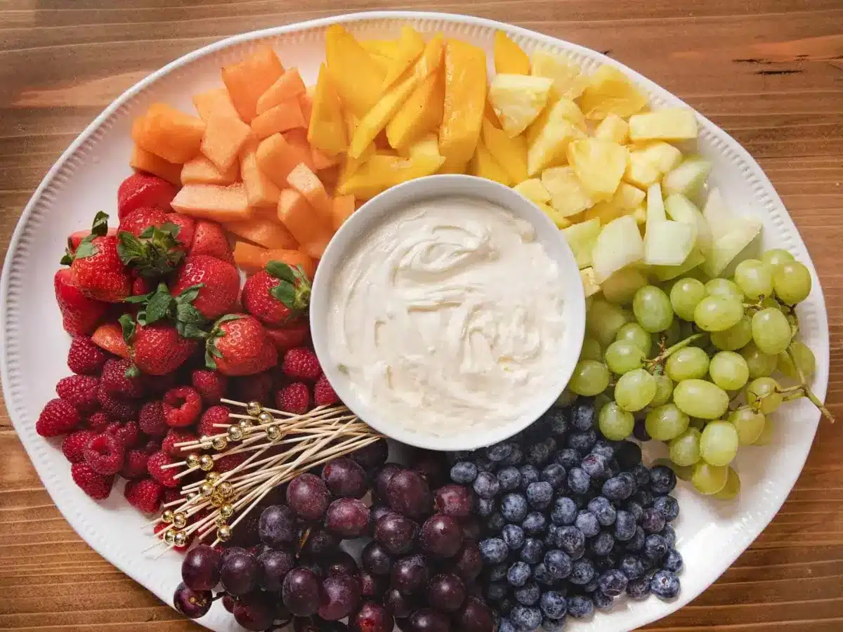 platter of dip in the center with colorful fruit surrounding it 