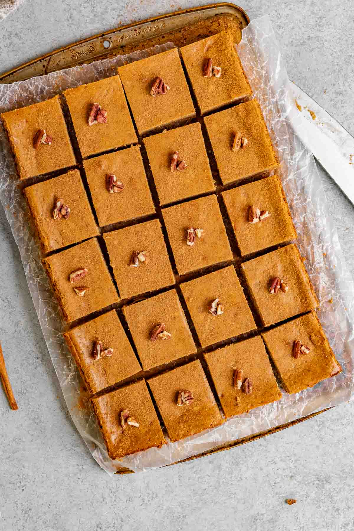 Gingerbread Cheesecake Bars sliced on a board with parchment