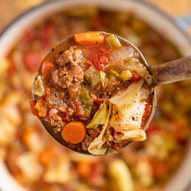 Ladle of cabbage soup over a pot