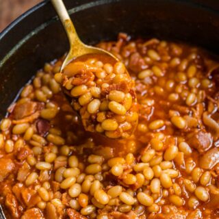 Homemade Pork and Beans with bacon and sauce in pot with spoon