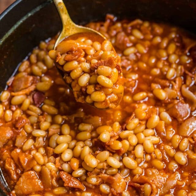 Homemade Pork and Beans with bacon and sauce in pot with spoon